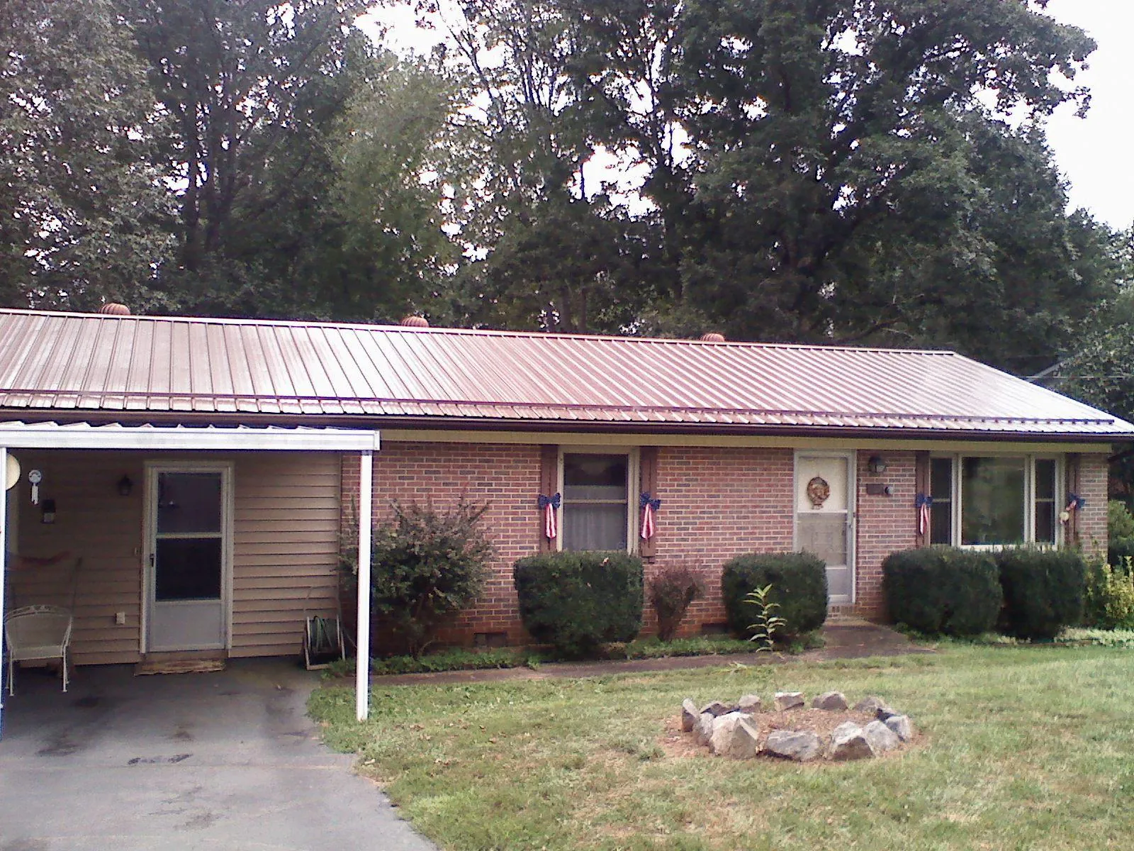 Bronze metal roof and carport on a brick ranch home — Roof Repair work by our crew in Orchard